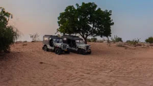 Gallery - Damodra Desert Camp 7 mahindra jeeps parked in sand dunes outside damodra desert camp